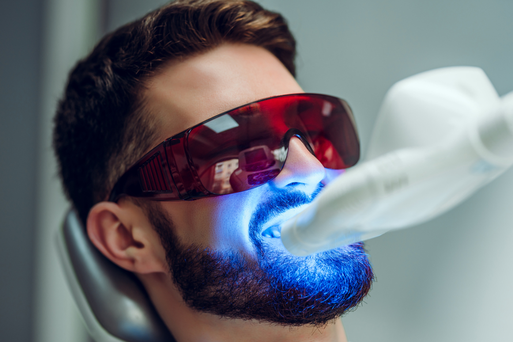 Teeth,whitening.,man,having,teeth,whitened,by,dental,uv,laser